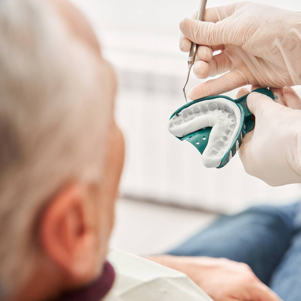 dentist showing patient dental impression